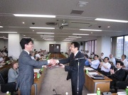 永田学長から表彰楯を受ける二瓶准教授(左)