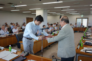東副学長から表彰楯を受ける山本准教授(左)