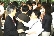 参加者と懇談する岩崎学長（左）