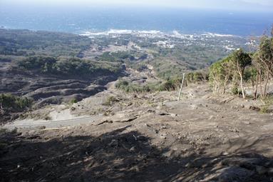 2013年10月の豪雨で崩壊した伊豆大島の地すべり現場。海岸沿いに住宅地が見える。