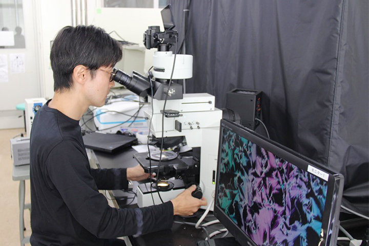 顕微鏡を覗く菱田さんの写真