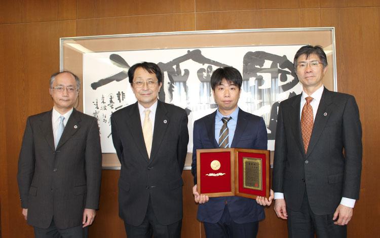 左から加藤和彦副学長、永田学長、山﨑教授、和田副学長