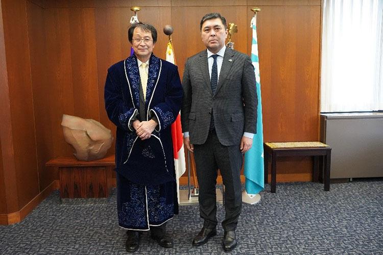 （左）大使から贈呈された民族衣装を着た永田学長（右）サーブル・エシムベコフ駐日大使
